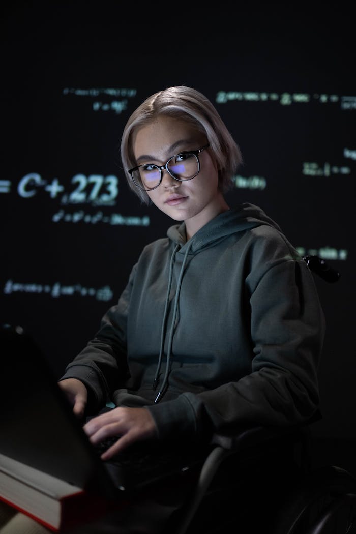 A Woman in a Hoodie Using a Laptop